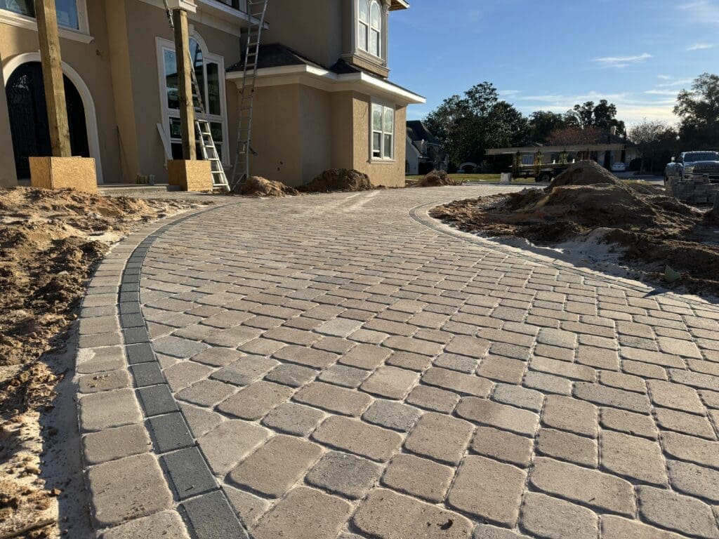 a brick walkway in front of a house under construction